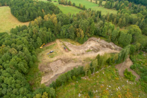 Drönarfotot över ett utgrävt område i en skogsdunge.